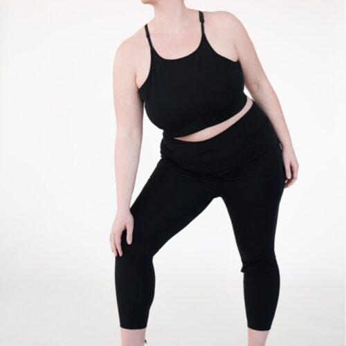 Plus size high impact leggings with a pocket in black colour while standing